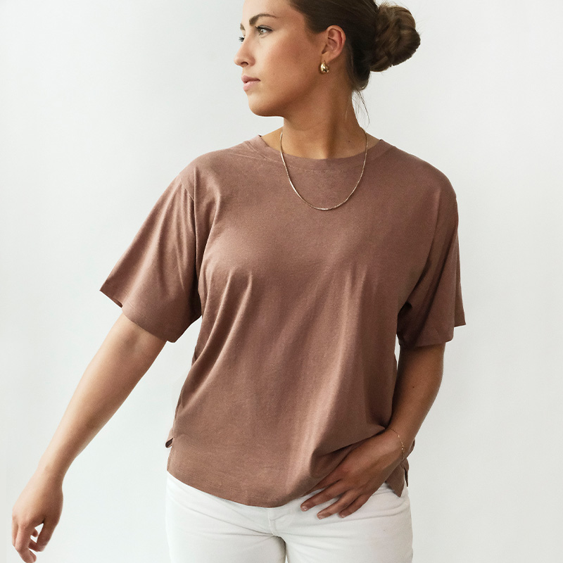 Modell som bär beige t-shirt i ekologisk bomull